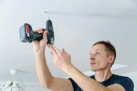 Installing a spotlight in the room. Stock Photos