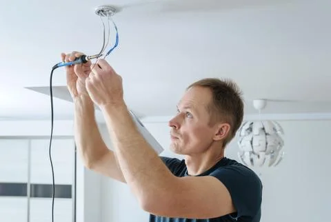 Installing a spotlight in the room. Stock Photos