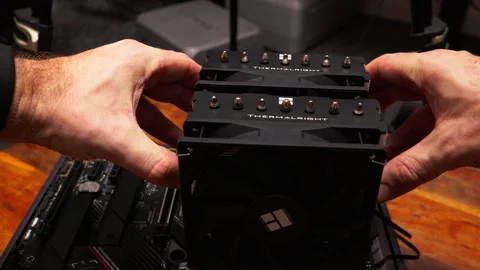 Installing a Thermalright CPU cooler. Hands assembling components for optimal Stock Footage 301636629
