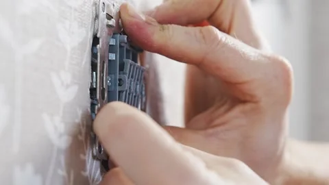 Installing a three-way light switch in a home electrical junction box Stock Footage 317743852