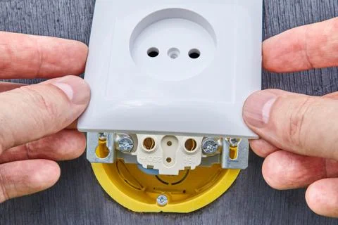 Installing top panel on household electrical socket. Stock Photos