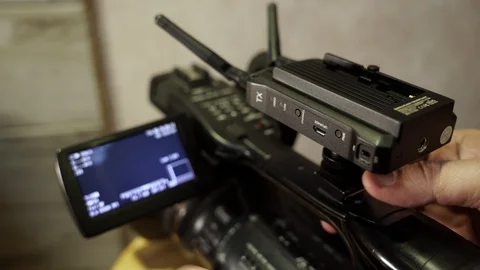 Installing the transmitter on the video camera. Video stock 130144582