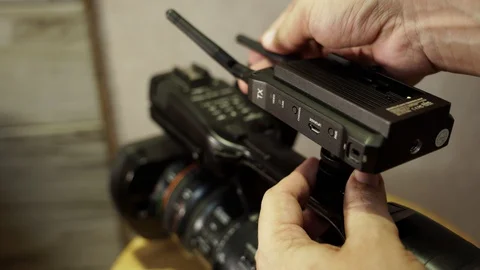 Installing the transmitter on the video camera. Video stock 130144763