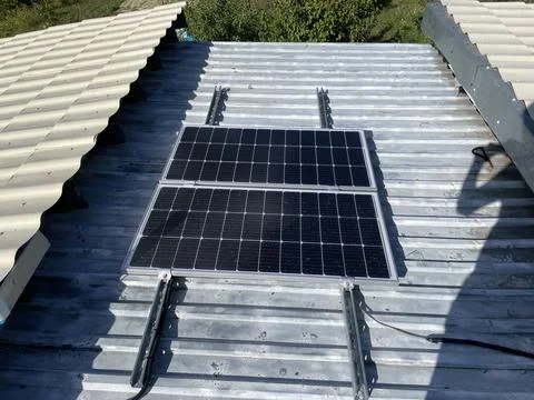 Installing two solar panels on roof Stock Photos