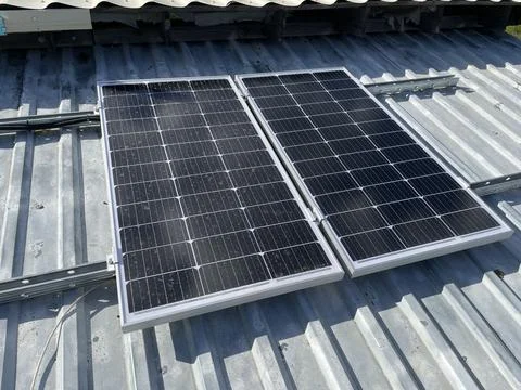 Installing two solar panels on roof Stock Photos