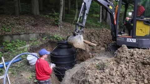 Installing underground plastic tank. Construction site of small water well Vidéo 251644420