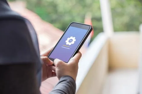 Installing update concept on phone screen. Woman hand hold phone doing install Stock Photos
