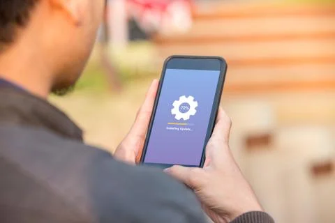 Installing update concept on phone screen. Man holding phone doing installing up Stock Photos