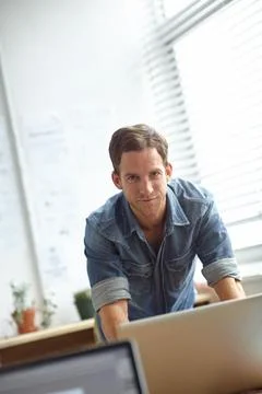 Installing useful programs. A handsome young man working on his laptop in the Foto stock