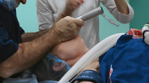Installing a ventilator in a patient during surgery. Intubating the patient for Stock Footage 122954763