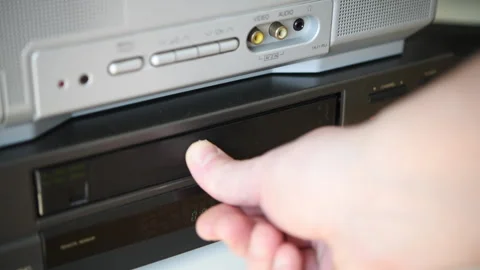 Installing a VHS video cassette into a VCR. Stock Footage 306228951