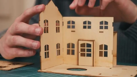 Installing wall panel during wooden house model construction. Hands assembling Stock-Footage 336309778
