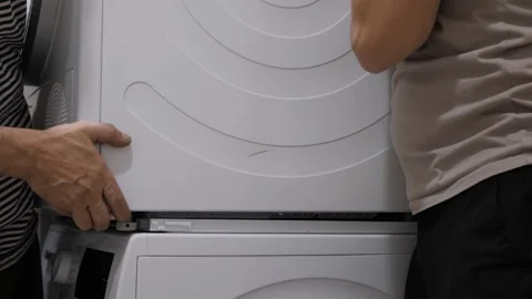Installing Washer and Dryer needs teamwork for efficiency Video stock 303385312