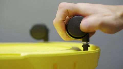 Installing wheels on a household vacuum cleaner. Close-up of hands 動画素材 290800917