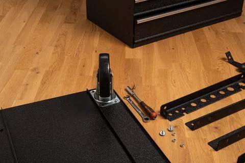 Installing wheels on rolling tool chest base Foto stock