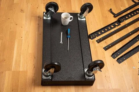 Installing wheels on rolling tool chest base Foto stock