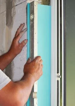Installing white polystyrene foam board insulation on a bare wall next to w.. Stock Photos