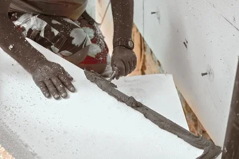 Installing white polystyrene heat insulation, detail on worker hand putting.. Stock Photos