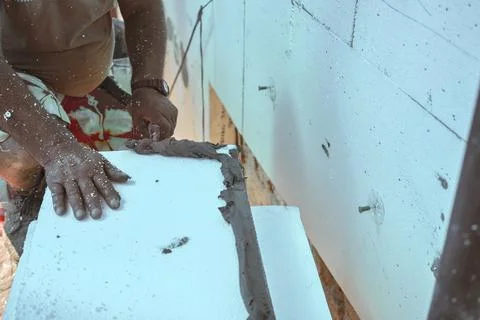 Installing white polystyrene heat insulation, detail on worker hand putting.. Stock Photos