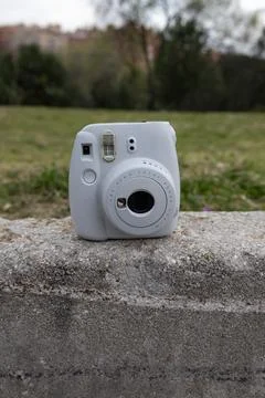 Instant camera resting on a stone wall outdoors Fotos de archivo