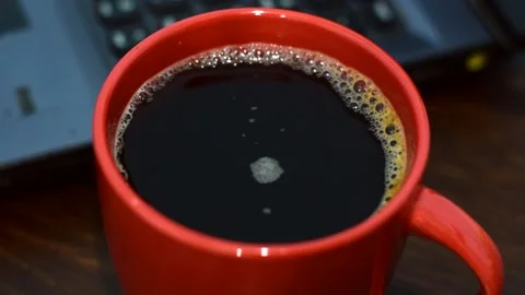 Instant coffee in a big red cup, laptop on the background. Stock Footage 151376677