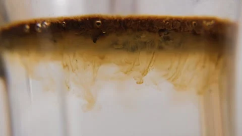 Instant coffee falling into hot water, macro shot Vídeo Stock 321954596