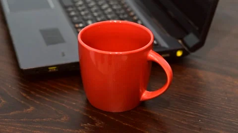 Instant coffee is placed in a large red cup and water is poured Stock Footage 151192190