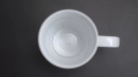 Instant coffee in a white mug on a black table. green spoon 스톡 동영상 128028532