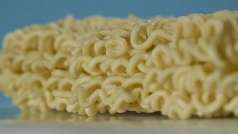 Instant dry pasta rotating on the table in macro on blue background 스톡 동영상 127409127