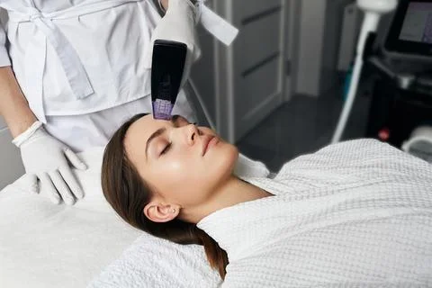 Instant lifting effect and wrinkle reduction for forehead skin of woman pat.. Stockfoto's