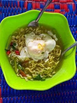 The instant noodle-based dish is served in a green bowl 库存照片