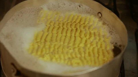 Instant noodles boiling in a pan, top view. Close-up of instant ramen cooking Stock Footage 336296622