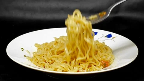 Instant noodles with fork, served with vegetables and herbs, on white plate Stock Footage 279295320