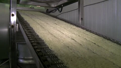 Instant noodles move continuously along a conveyor belt in a pasta factory. Stock Footage 149072707