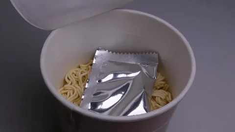 An Instant ramen opened and a hand takes out from inside a folded plastic fork Stock Footage 316219022