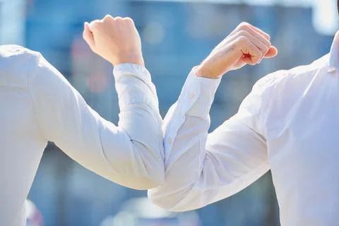 Instead of greeting with hug or handshake man and woman bump elbows on a stre Stock Photos