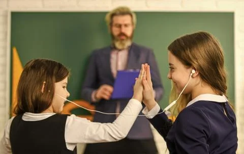 Instead studying. Problem of smartphones in schools. School students and teacher Stock Photos