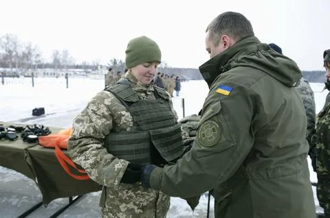 Instructing officer teaching recruit to put the bulletprof on. February 1, 20 Stock Photos