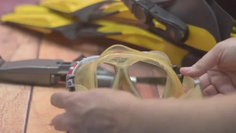 Instructional video of hands cleaning a diving mask to prepare for underwater Stock Footage 313649861