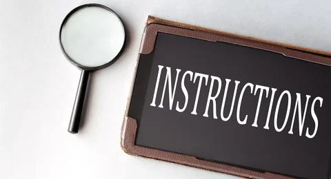 INSTRUCTIONS - word in electronic notebook on white background with magnify.. Stock Photos