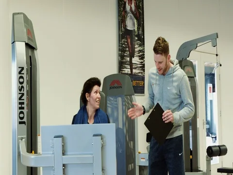 Instructor advising woman during work out at the gym Stock Footage 72987801