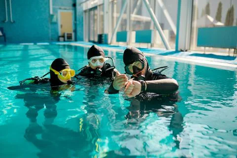 Instructor and divers in aqualungs, dive lesson Stock Photos