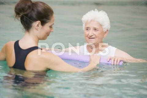 Instructor And Elderly Patient Undergoing Water Therapy Stock Photos