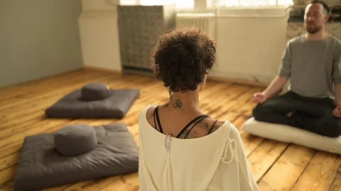 Instructor and female student doing meditation exercise in yoga class Stock Footage 112999294