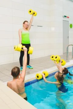 Instructor and group of children doing exercises in a swimming pool Stock Photos