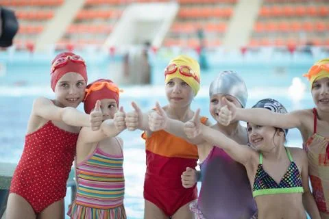 Instructor and group of children doing exercises near a swimming pool Stock Photos