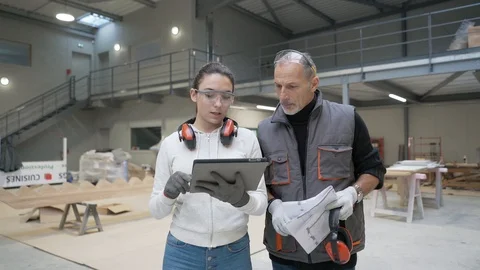 Instructor with apprentice in carpentry warehouse using tablet Stock Footage 123162923