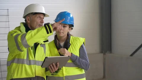 Instructor with apprentice on construction site working with tablet Stock Footage 123215641