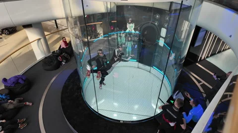 Instructor Assisting Student In Indoor Skydiving Tunnel Stock Footage 335135402