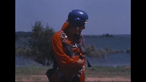 Instructor attaching harness to Astronaut parachute - 1968 Stock Footage 104331180